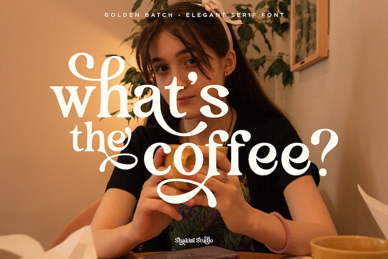 Op de afbeelding: Een persoon die een gele mok vasthoudt met de tekst "what's the coffee?" in een wit elegant schreeflettertype. De tekst "GOLDEN BATCH - ELEGANT SERIF FONT" staat bovenaan. Het Shakini Studio-logo staat onderaan.