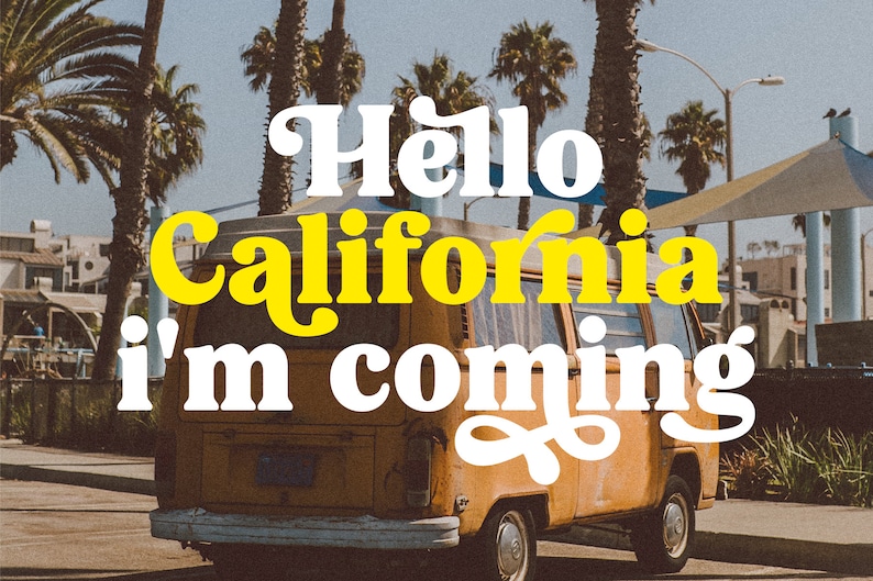 Op de afbeelding: Een gele vintage bus met de tekst "Hello California I'm coming" in witte en gele letters aan de zijkant. De bus staat geparkeerd voor een rij palmbomen.