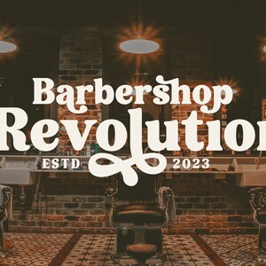 Op de afbeelding: Een barbershop interieur met bakstenen muren, vintage verlichting en twee zwarte leren kappersstoelen. Het bord boven de stoelen luidt "Barbershop Revolution ESTD 2023".