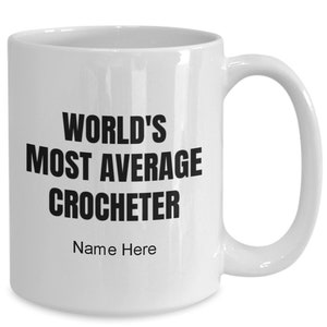 May include: White ceramic coffee mug with black text that reads "World's Most Average Crocheter" and "Name Here".