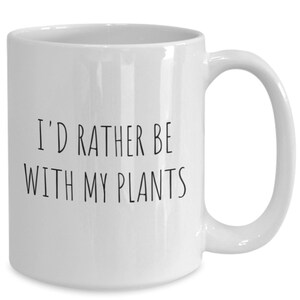 May include: White ceramic coffee mug with black text that reads "I'd rather be with my plants".