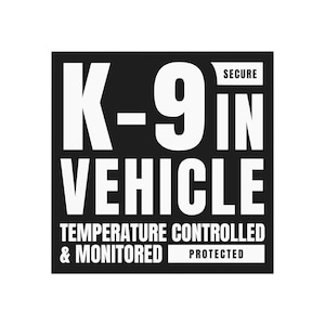 May include: Black and white rectangular sign with the text "K-9 IN VEHICLE" in large, bold, white letters. Additional text reads "TEMPERATURE CONTROLLED & MONITORED PROTECTED" and "SECURE".