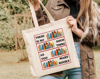 May include: A white canvas tote bag with the text "There is no such thing as too many books" printed on it. The text is surrounded by a graphic of colourful books.