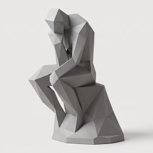 May include: A light gray sculpture of a seated figure in a contemplative pose, constructed with a geometric, faceted, low-poly design. The figure rests its chin on one hand, with sharp angular planes forming the body and the base it sits upon.