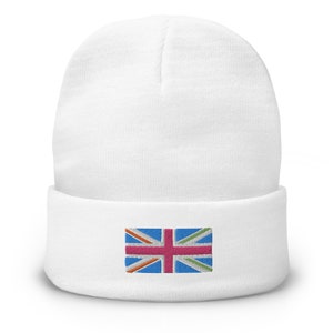 May include: A white beanie with a folded brim. The beanie features an embroidered rectangular patch with a stylized Union Jack design in blue, pink, orange, and green. The hat is made of a soft, knitted material.