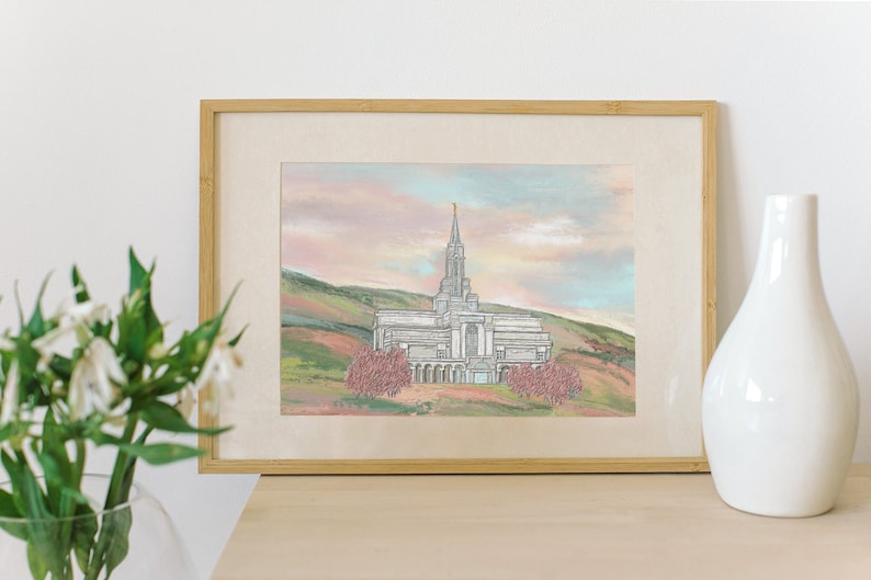 Peut inclure: Une peinture &agrave; l'aquarelle encadr&eacute;e d'un temple blanc avec une haute fl&egrave;che, entour&eacute; d'arbres et de collines. Le ciel est d'un rose et d'un bleu doux.