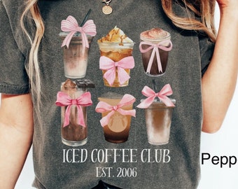 May include: A gray t-shirt with a graphic of iced coffee drinks with pink bows and the text "ICED COFFEE CLUB EST. 2006".