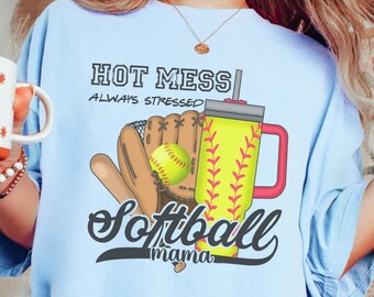 May include: Light blue t-shirt with a graphic of a softball glove, ball, and a tumbler with the text "Hot Mess Always Stressed Softball Mama".