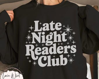 Może przedstawiać: Czarna bluza z białym napisem "Late Night Readers Club" i grafiką gwiazd. Bluza ma okrągły dekolt.