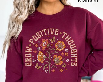 May include: A maroon sweatshirt with a floral design and the text "Grow Positive Thoughts" in a circle.