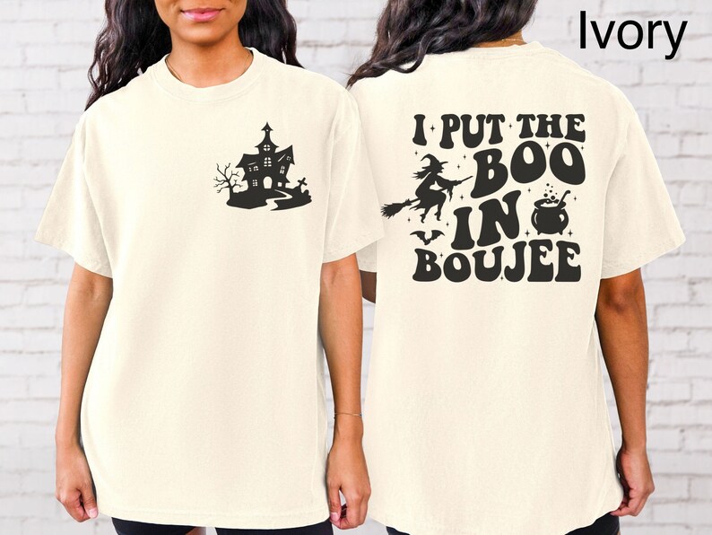 May include: Ivory short-sleeved t-shirt with a black graphic of a haunted house on the front and the text "I put the boo in boujee" on the back.