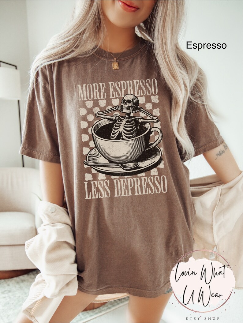 May include: A brown t-shirt with a skeleton in a coffee cup graphic and the text "More Espresso Less Depresso".