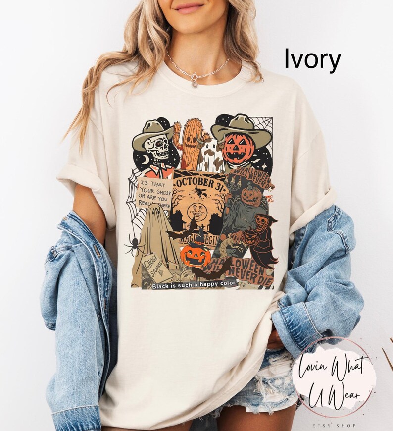 May include: Ivory-colored t-shirt with a Halloween-themed graphic. The design includes a skull, cactus, pumpkin, and other spooky elements. Text on the shirt reads "October 31" and "Halloween Never Die."