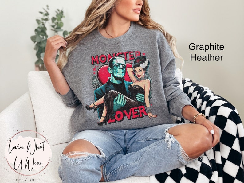Peut inclure: Un sweat-shirt gris avec un imprim&eacute; graphique de Frankenstein et sa fianc&eacute;e. Le texte sur le sweat-shirt est "Monster Lover".