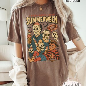 K&ouml;nnte beinhalten: Espressofarbenes T-Shirt mit einem Aufdruck von Horrorfilmfiguren, die Eiswaffeln halten. Der Text "I FREAKING LOVE SUMMERWEEN" steht &uuml;ber den Figuren, mit einer Sprechblase mit der Aufschrift "CAN I GET SOME ICE SCREAM, PLEASE?"