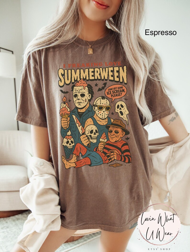 K&ouml;nnte beinhalten: Espressofarbenes T-Shirt mit einem Aufdruck von Horrorfilmfiguren, die Eiswaffeln halten. Der Text "I FREAKING LOVE SUMMERWEEN" steht &uuml;ber den Figuren, mit einer Sprechblase mit der Aufschrift "CAN I GET SOME ICE SCREAM, PLEASE?"