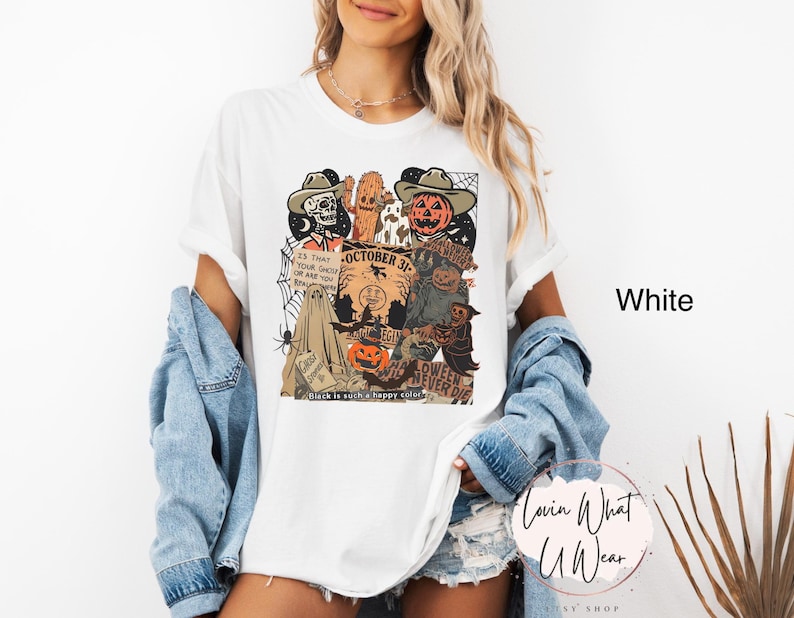 May include: White t-shirt with a Halloween-themed graphic. The design features a skeleton, cactus, and pumpkin wearing cowboy hats, along with the text "October 31" and "Halloween Never Die". The shirt also has a spider web and a ghost.