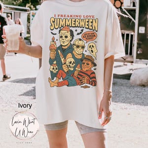 K&ouml;nnte beinhalten: Elfenbeinfarbenes T-Shirt mit dem Text "I FREAKING LOVE SUMMERWEEN" und einer Grafik von Horrorfilmfiguren, die Eiswaffeln halten. Das Shirt hat auch den Text "CAN I GET SOME ICE SCREAM, PLEASE?"