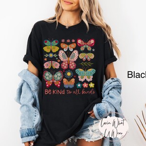 May include: Black t-shirt with a colorful butterfly design and the text "Be Kind to all kinds".