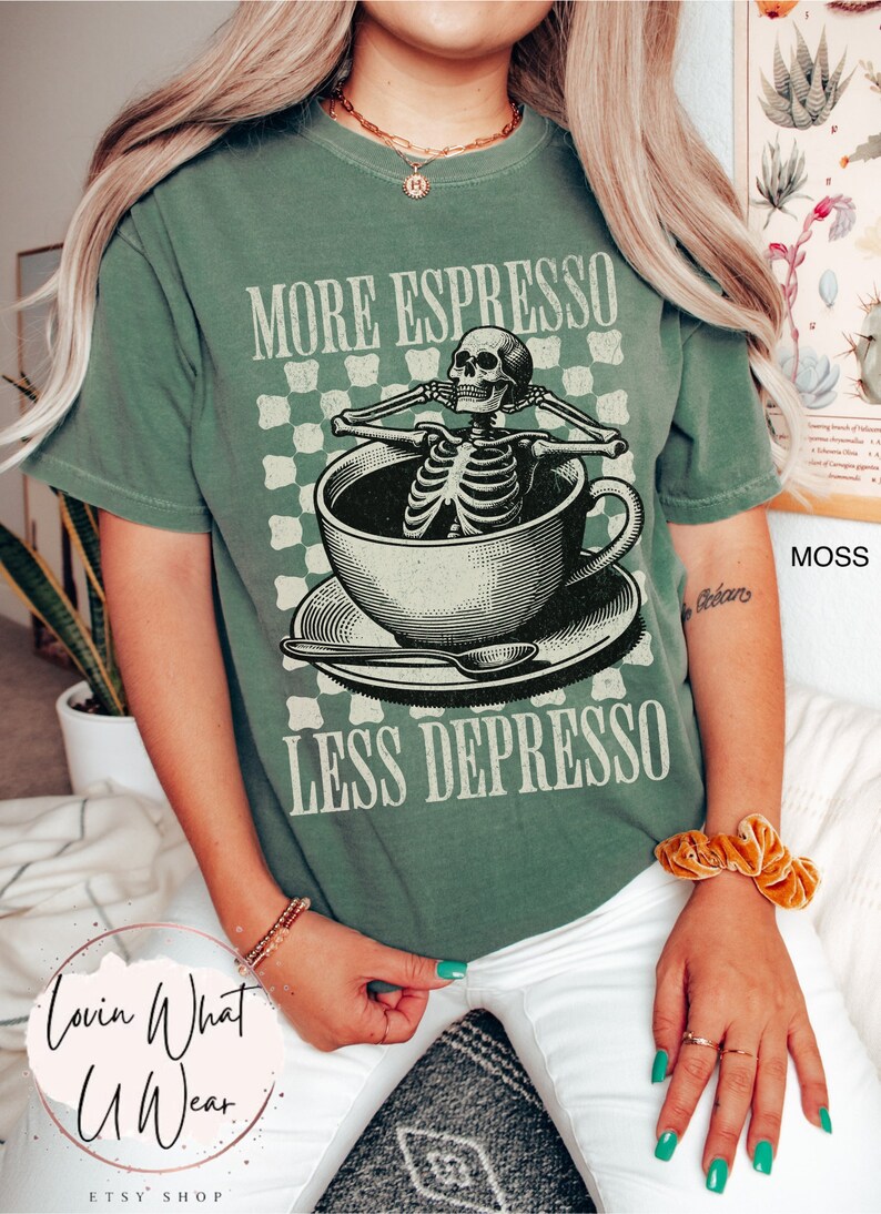 May include: A green t-shirt with a skeleton sitting in a coffee cup. The text on the shirt reads "More Espresso Less Depresso".