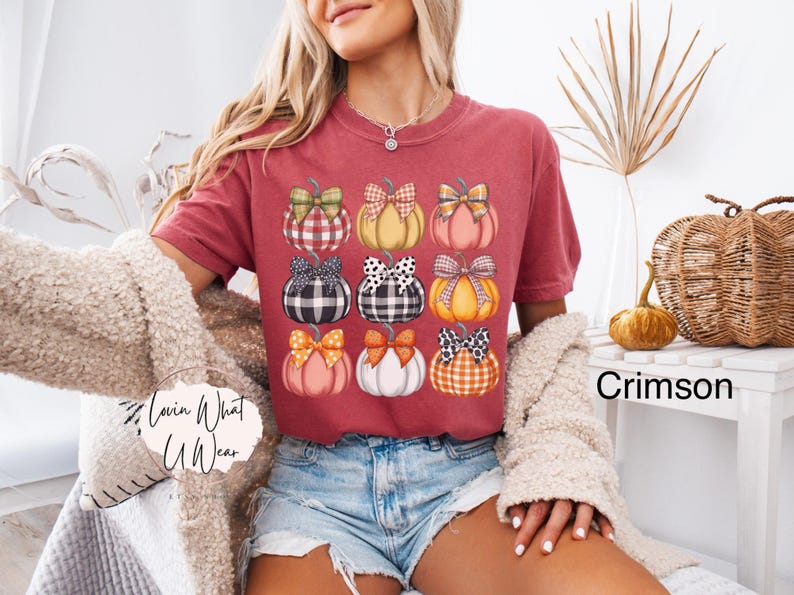 Peut inclure: T-shirt couleur cramoisi avec une grille de neuf citrouilles &agrave; n&oelig;uds &agrave; motifs. Les citrouilles ont diff&eacute;rentes couleurs et motifs, notamment des carreaux, des pois et des couleurs unies. Le t-shirt est associ&eacute; &agrave; un short en jean.