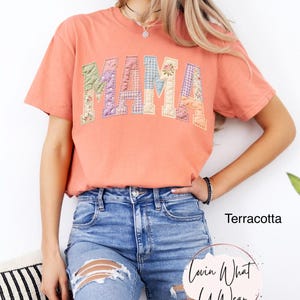 Puede incluir: Camiseta color terracota con la palabra "MAMA" en letras de patchwork. Las letras est&aacute;n hechas de varias telas florales y estampadas. La camiseta se combina con pantalones cortos de mezclilla azules. El texto "Terracota" es visible.