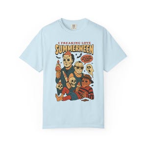 May include: Pale blue t-shirt with a graphic of horror movie characters holding ice cream cones. The text "I FREAKING LOVE SUMMERWEEN" is above the characters, with a speech bubble that says "CAN I GET SOME ICE CREAM PLEASE?"