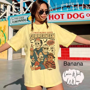 K&ouml;nnte beinhalten: Hellgelbes T-Shirt mit dem Text "I Freaking Love Summerween" und einer Grafik von Horrorfilmfiguren mit Eis. Das Shirt ist mit "Banana" beschriftet und hat ein Logo mit der Aufschrift "Lovin What U Wear".