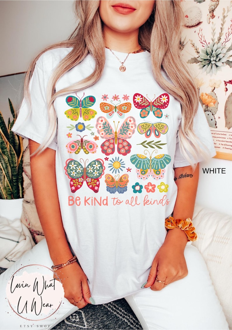 May include: White t-shirt with a colorful butterfly design and the text "Be Kind to all kinds".