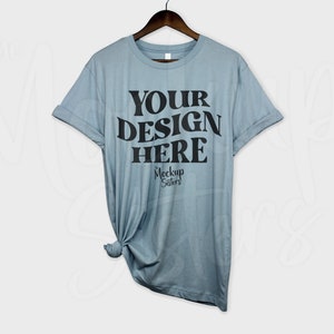 May include: A light blue t-shirt with rolled up sleeves. The shirt has the text "YOUR DESIGN HERE" printed on the front in black.