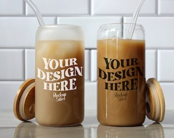 May include: Two iced coffee drinks in glass mugs with lids and straws. The mugs have the text "Your Design Here" printed on them. 