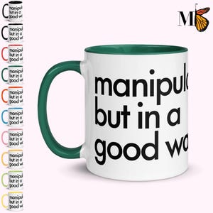 May include: White ceramic mug with a green handle and interior rim. The mug features the text "manipulative but in a good way" in large black letters. A butterfly logo is in the upper right corner. Several other mugs with different colored handles are shown.