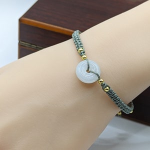 Handmade lucky bracelet with a green jadeite safety pendant, adjustable (手工编织晴绿翡翠平安扣手链, 可调节)
