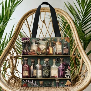 May include: A tote bag with a print of apothecary bottles on shelves. The bag has a black handle and is set against a wicker chair and green plants. The bottles are various shapes and sizes, with labels and corks.