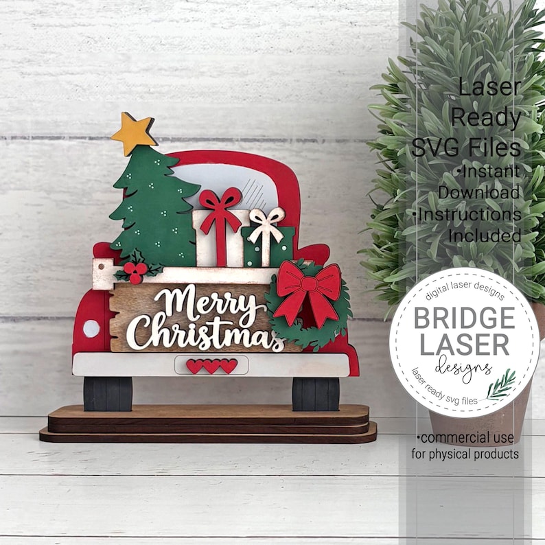 May include: A layered wooden cutout of a red truck bed carrying a green Christmas tree, two gift boxes with bows, and a wreath. The truck features a sign with the text Merry Christmas, three small red hearts, and a yellow star on the tree.