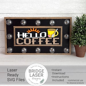 Könnte beinhalten: Ein Schild aus Holz mit Glühbirnen um den Umfang, mit dem Text "HELLO COFFEE" in einer schwarzen und weißen Schrift. Das Schild enthält auch eine stilisierte Sonne und eine Kaffeetasse mit einem gelben Henkel und einem rosa Herzen.