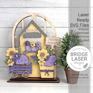 May include: A wooden decorative piece featuring a yellow house with a gray roof, adorned with purple and yellow flowers. A small sign reads "Sunshine and Blooms." The design includes a flower cart and a flower pot, with the text "Fresh Flowers" above the house.