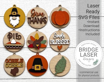 May include: A collection of laser-cut wooden Thanksgiving ornaments. Each ornament features a different design, including a pumpkin, turkey, and the words "Give Thanks" and "Simply Blessed." The image also includes the text "Laser Ready SVG Files."