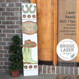 May include: A white wooden welcome sign with a cowboy theme. It features a horseshoe, the words "Howdy Y'all" with cacti, a cowboy hat, and boots. The sign also includes the text "Laser Ready SVG Files" and "Bridge Laser Designs".