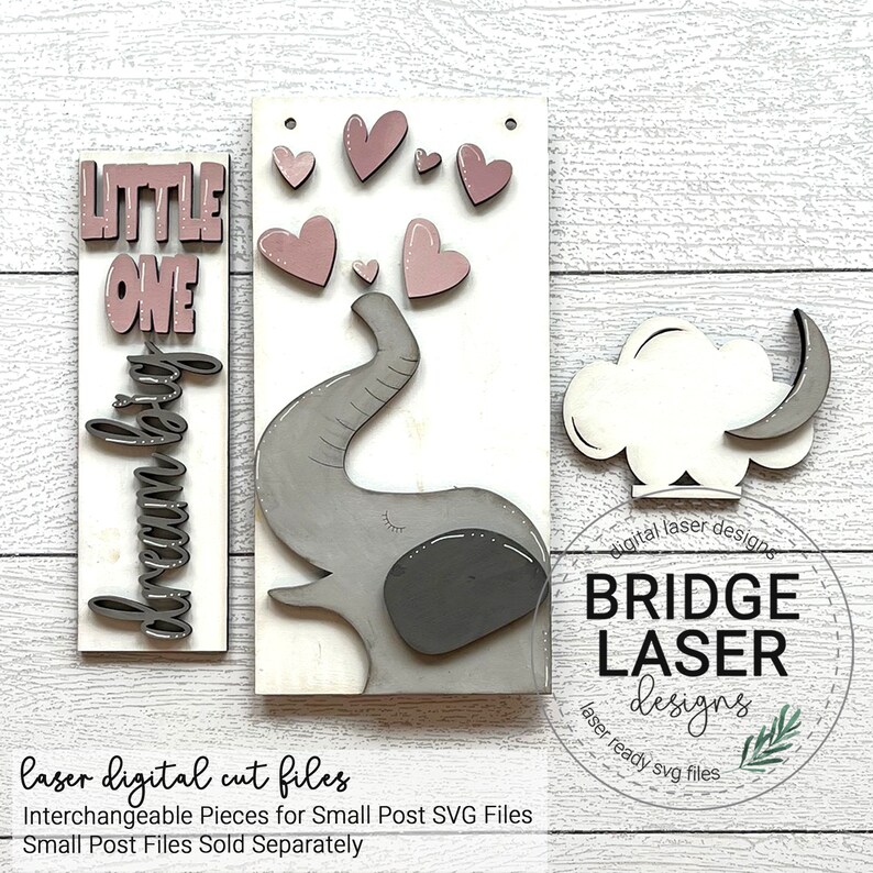 May include: A digital cut file design for a layered wooden sign with the words "Little One" and "dream big" in pink and gray, an elephant with pink hearts, and a cloud with a crescent moon. The design is for a small post SVG file.