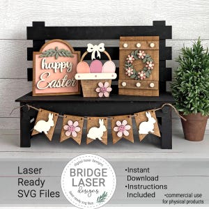 Könnte beinhalten: Osterdekorationen aus Holz auf einer schwarzen Bank. Enthält ein Schild mit "Happy Easter", einen Korb mit Eiern und eine Tür mit einem Blumenkranz. Ein Banner mit Hasen und Blumen hängt darunter. Eine kleine Topfpflanze befindet sich rechts.