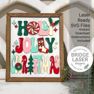 May include: A rectangular wooden sign featuring the text HOLY JOLLY CHRISTMAS in layered, colorful letters. The design includes a peppermint candy, a stocking, a wreath, and a pine tree. The sign is framed in dark wood with a white background.