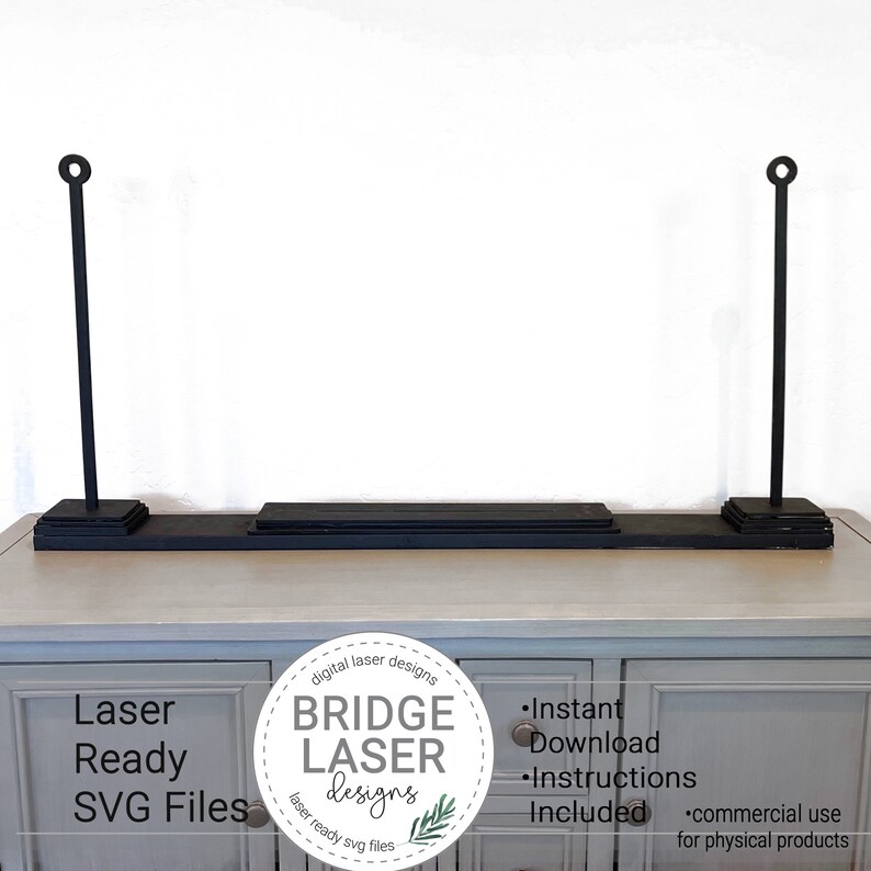 May include: Black laser-cut shelf with two vertical supports, each topped with a circular design. The shelf sits on a light-colored cabinet. The image includes text that reads "Laser Ready SVG Files" and "Bridge Laser Designs."