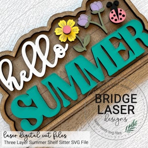 May include: A three-layer wooden shelf sitter with the words "hello summer" in white and teal lettering. The shelf sitter is decorated with flowers and a ladybug.