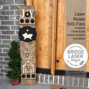 Puede incluir: Un letrero vertical de madera alto con diseños cortados a láser que incluyen la palabra JOY, un nacimiento, el texto O HOLY NIGHT y la silueta de un establo. El letrero tiene acabados en madera negra y natural con estrellas. Texto: Laser Ready SVG Files.