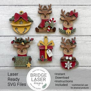 May include: Six wooden Christmas ornaments featuring a yellow bell with a red bow, a reindeer with a candy cane, a reindeer with a bell, a reindeer holding a sign that says MERRY & BRIGHT, a red gift box with a tag saying JOY, and a reindeer in a mug.