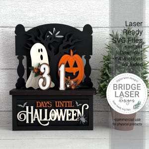 May include: A black and white Halloween countdown decoration. It features a ghost, a pumpkin, and the numbers 31. The words "DAYS UNTIL HALLOWEEN" are displayed on the front. The decoration is made of wood and has a decorative tree in the background.