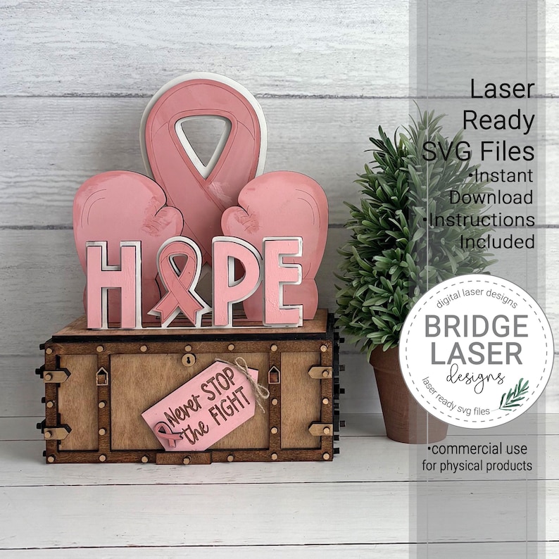 May include: A wooden tiered tray decor set featuring a pink awareness ribbon, two pink boxing gloves, and the word HOPE with a ribbon icon. A small pink tag attached to the base reads Never Stop the Fight. The set includes laser ready SVG files.