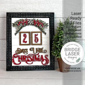 May include: A black framed sign with a white background and red and green Christmas decorations. The sign says "25 Days Until Christmas".