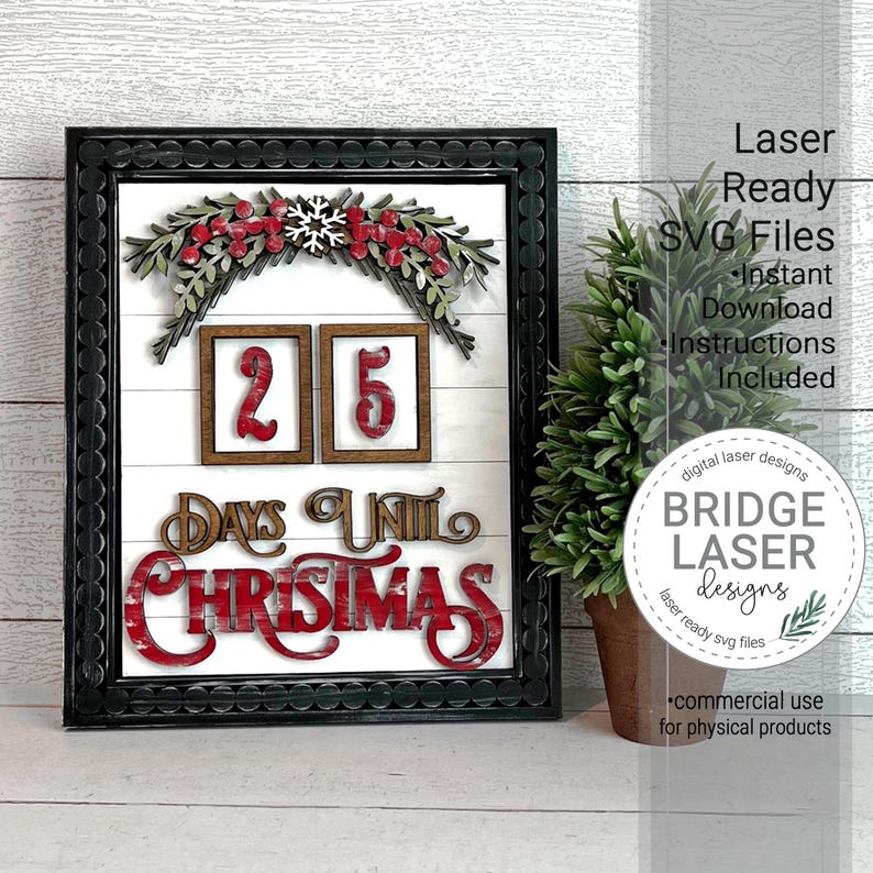May include: A black framed sign with a white background and red and green Christmas decorations. The sign says "25 Days Until Christmas".